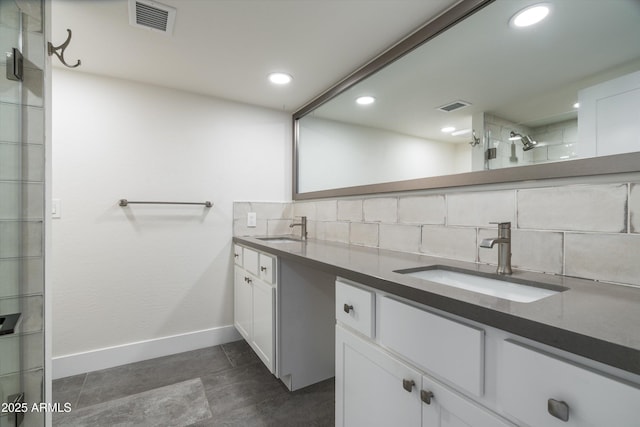 4434 E Camelback Rd Unit 132, Phoenix, AZ 85018 - bathroom with double vanity, decorative backsplash, a tile shower, recessed lighting, and tile patterned floors