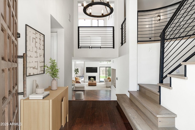 4434 E Camelback Rd Unit 132, Phoenix, AZ 85018 - foyer with a towering ceiling, dark wood finished floors, stairway, a chandelier, and a fireplace