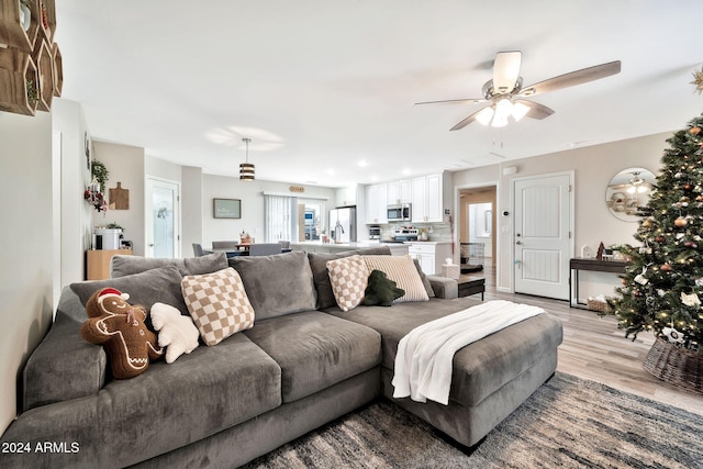 living room featuring ceiling fan and light hardwood / wood-style flooring