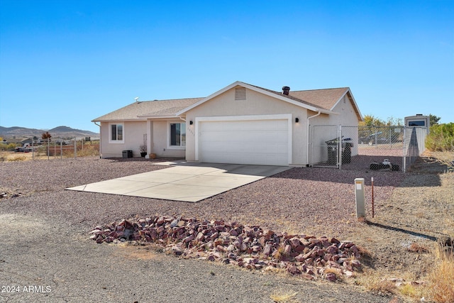 ranch-style house with a mountain view, a garage, and central AC