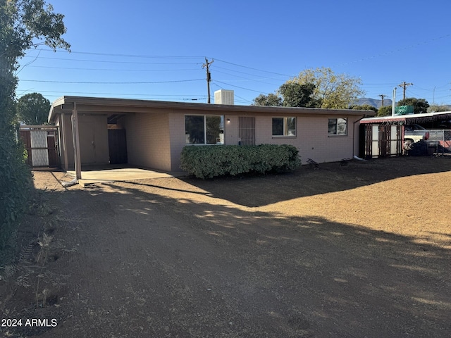 view of front of property featuring central AC unit and a carport