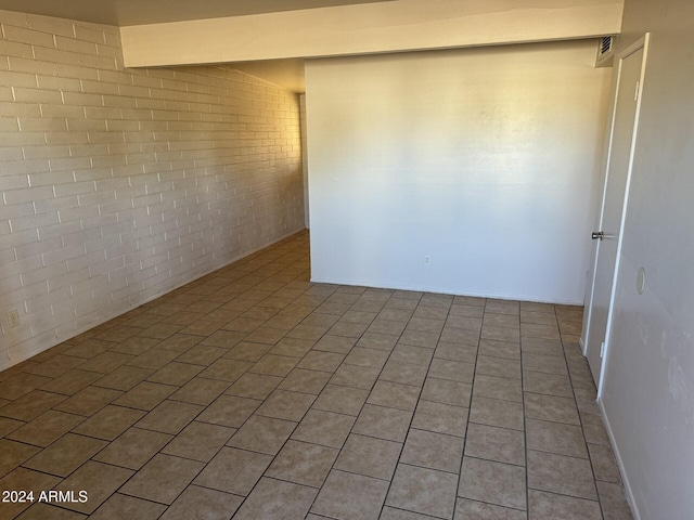 empty room featuring brick wall