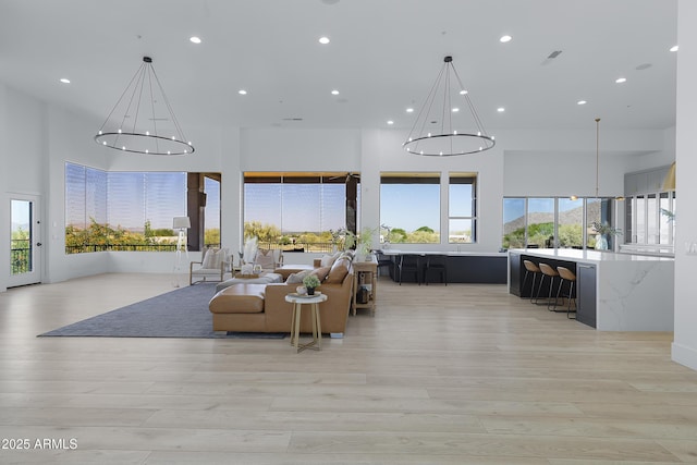 living area with a chandelier, light wood finished floors, and recessed lighting