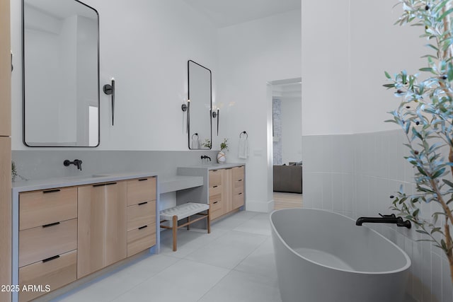 full bath with a soaking tub, vanity, and tile patterned flooring