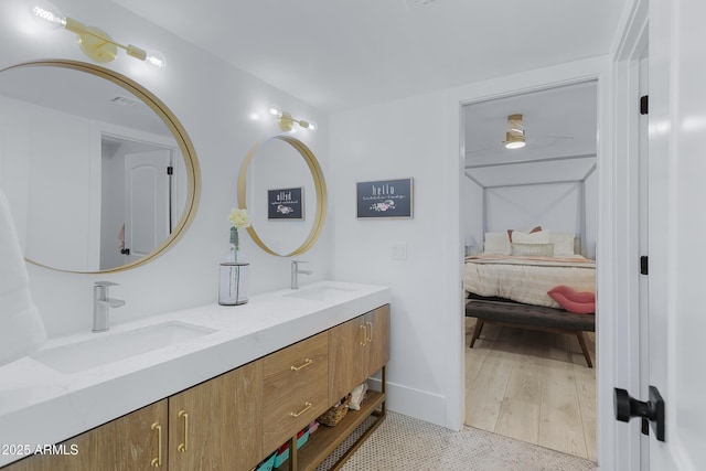 full bathroom with double vanity, ensuite bathroom, and a sink