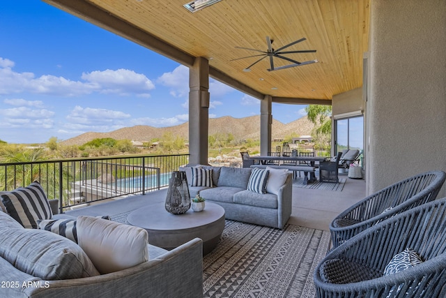 view of patio featuring outdoor dining space, an outdoor living space, a mountain view, and a ceiling fan