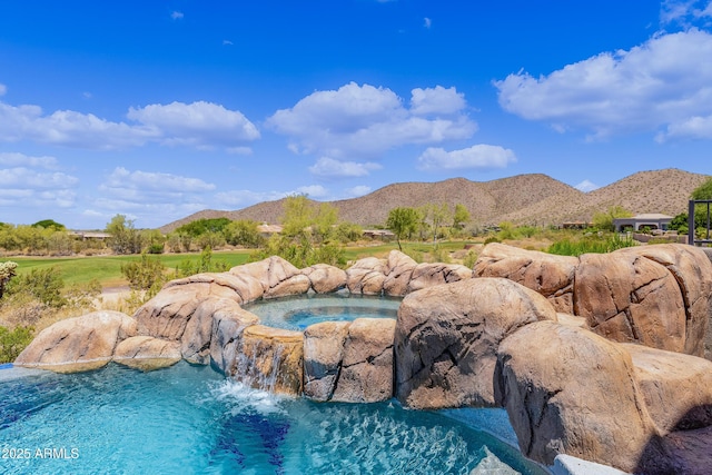 view of swimming pool featuring a mountain view and an in ground hot tub