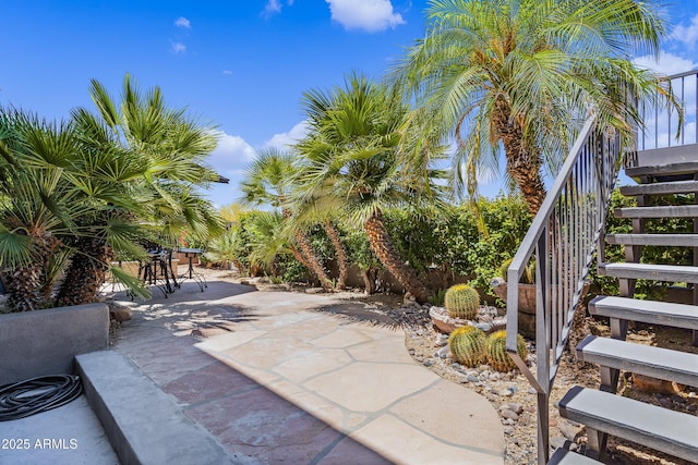 view of patio with outdoor dining space and stairs