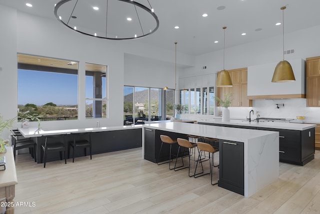 kitchen with light countertops, dark cabinetry, and a spacious island