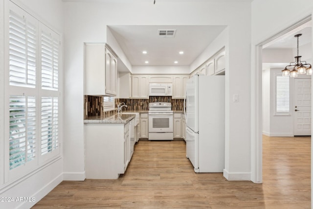 kitchen with a healthy amount of sunlight, white appliances, and white cabinetry