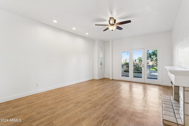 unfurnished living room with a fireplace, light wood-type flooring, and ceiling fan