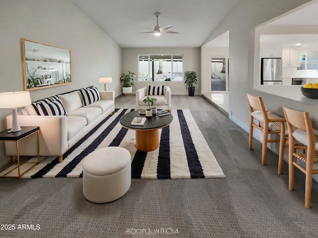 living area with lofted ceiling, ceiling fan, and baseboards