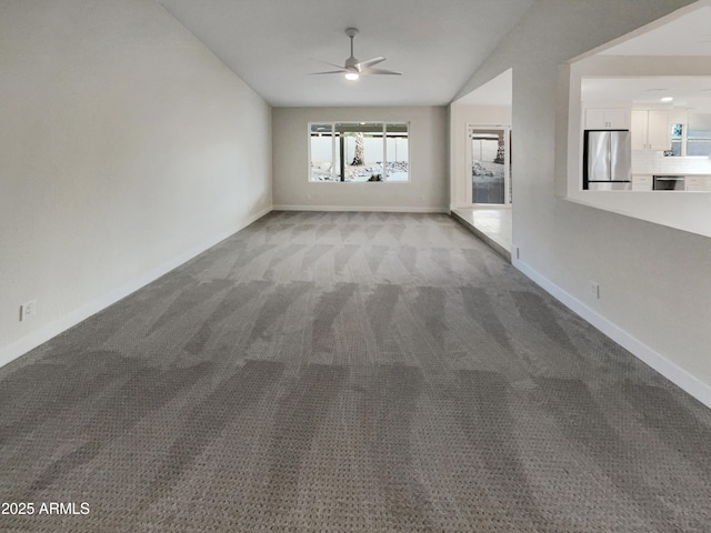 unfurnished living room featuring lofted ceiling, carpet floors, a ceiling fan, and baseboards