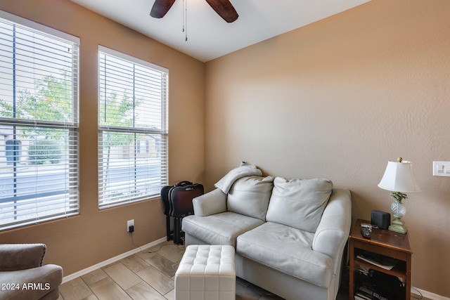 living area with ceiling fan, plenty of natural light, and light wood-type flooring