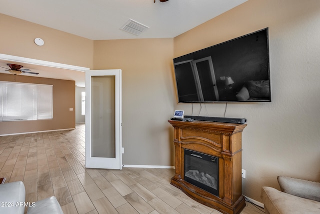 living room with ceiling fan, light hardwood / wood-style floors, and french doors