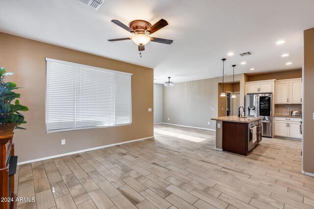 kitchen featuring decorative light fixtures, light hardwood / wood-style floors, a kitchen island with sink, and stainless steel refrigerator with ice dispenser