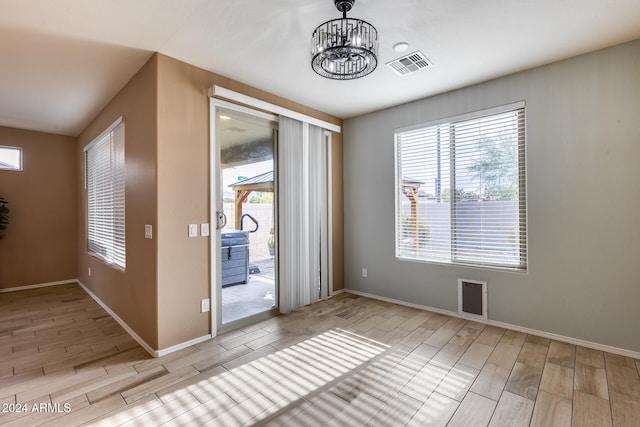 entrance foyer with light hardwood / wood-style floors and a notable chandelier