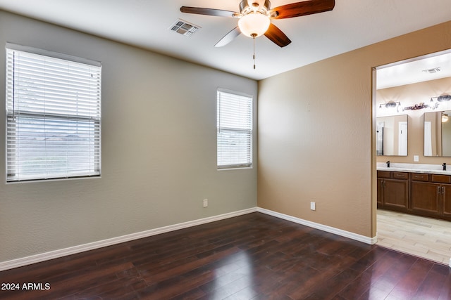 unfurnished bedroom with wood-type flooring, ensuite bath, ceiling fan, and sink