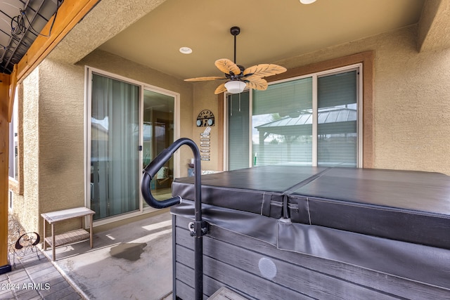 view of patio / terrace featuring ceiling fan and a hot tub