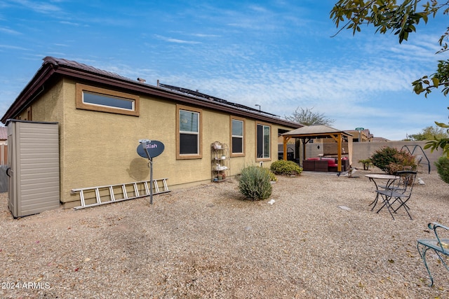 back of property with a gazebo