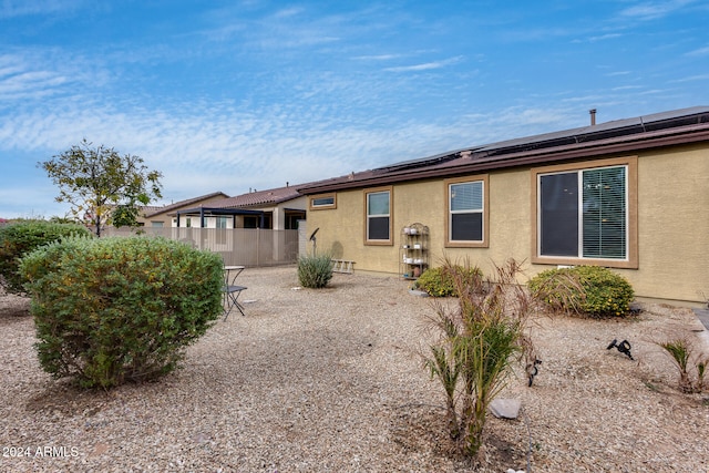 rear view of property featuring solar panels and a patio