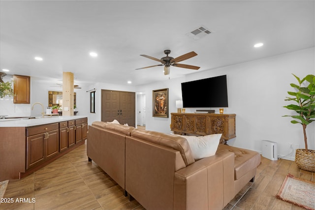 living room featuring visible vents, light wood finished floors, a ceiling fan, and recessed lighting