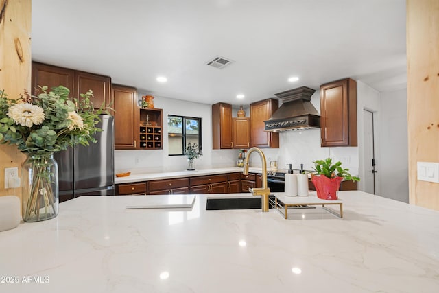 kitchen featuring premium range hood, recessed lighting, a sink, and light stone countertops