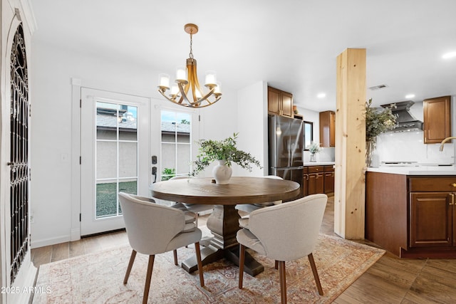 dining space with recessed lighting, a notable chandelier, visible vents, french doors, and light wood-type flooring