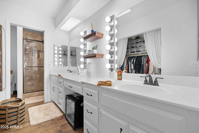 bathroom featuring a stall shower, a sink, and double vanity