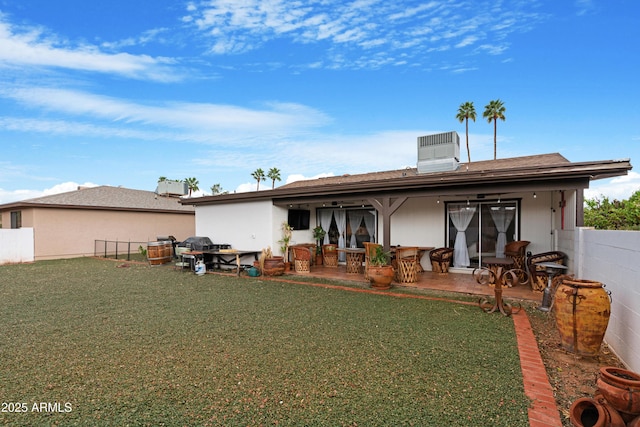 back of house featuring a yard, a patio, and fence