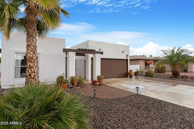 southwest-style home featuring a garage, concrete driveway, and stucco siding