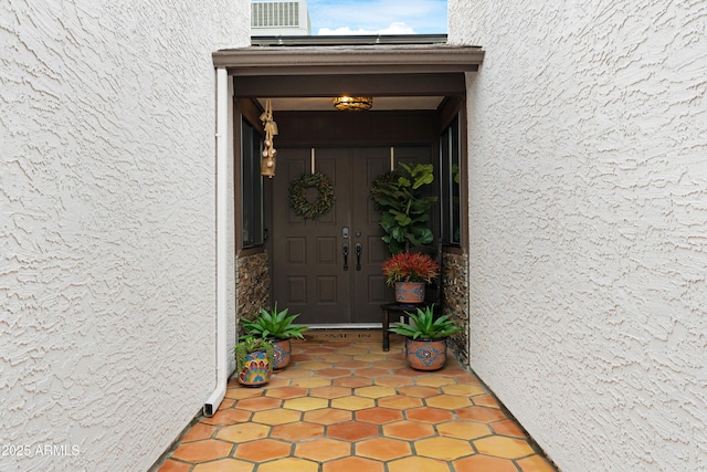 doorway to property featuring stucco siding