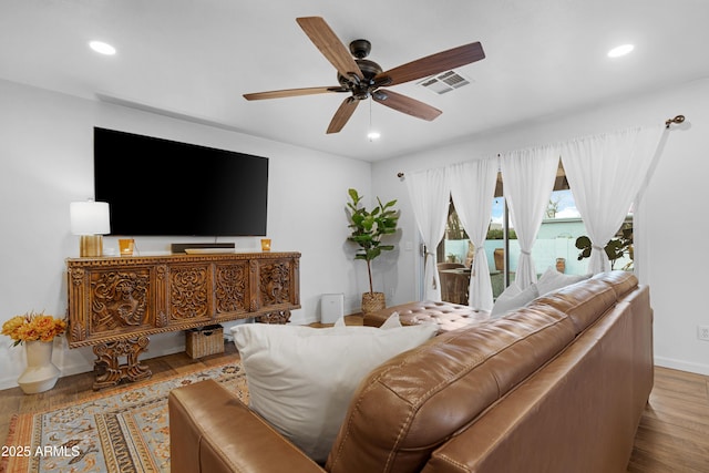 living area featuring a ceiling fan, wood finished floors, visible vents, and recessed lighting