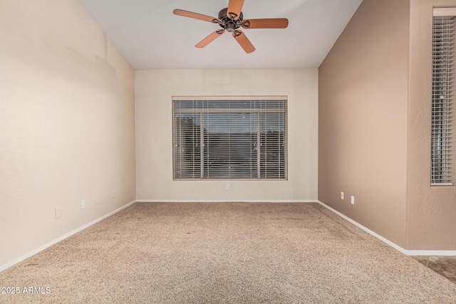carpeted spare room featuring baseboards and a ceiling fan