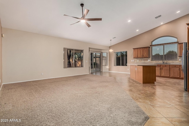 unfurnished living room with high vaulted ceiling, recessed lighting, a sink, and a ceiling fan