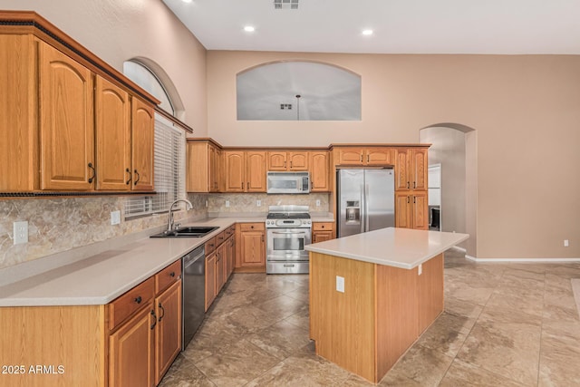 kitchen with arched walkways, visible vents, appliances with stainless steel finishes, a sink, and decorative backsplash