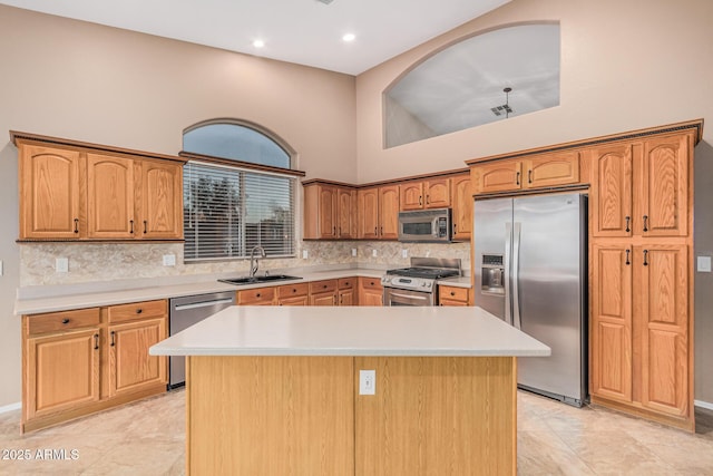 kitchen featuring tasteful backsplash, a center island, a high ceiling, a sink, and stainless steel appliances