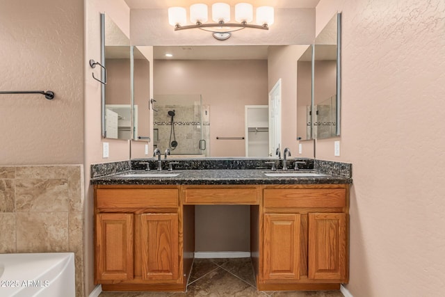 bathroom featuring a stall shower, double vanity, a sink, and a washtub