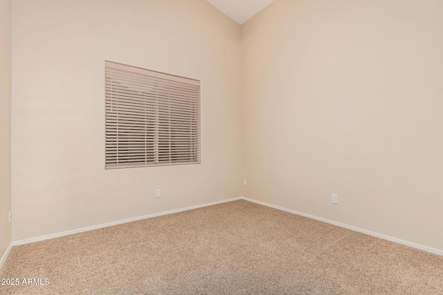 unfurnished room with carpet flooring, baseboards, and lofted ceiling