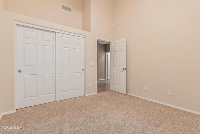 unfurnished bedroom featuring a closet, visible vents, baseboards, and carpet