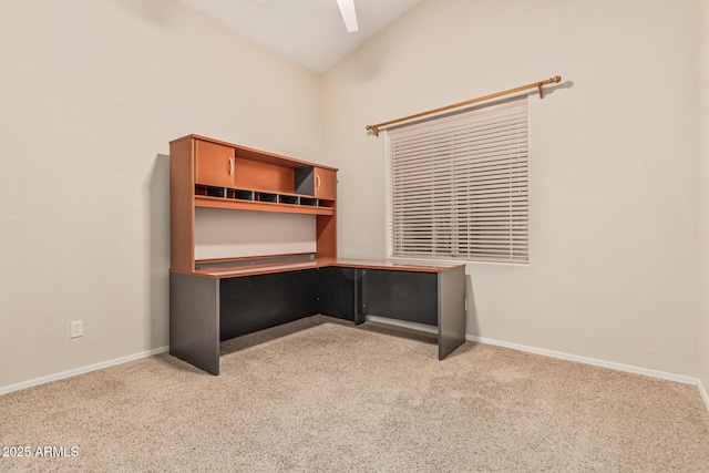 unfurnished office featuring ceiling fan, baseboards, vaulted ceiling, and carpet floors