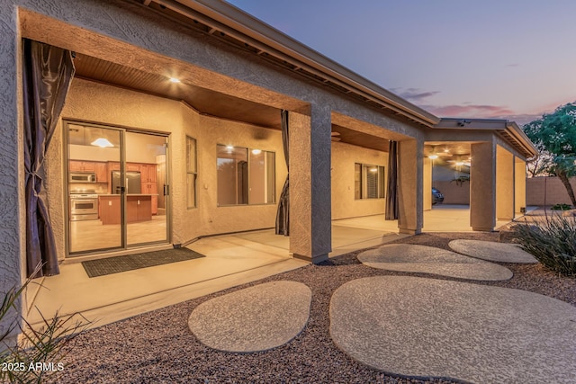 rear view of property with a patio and stucco siding