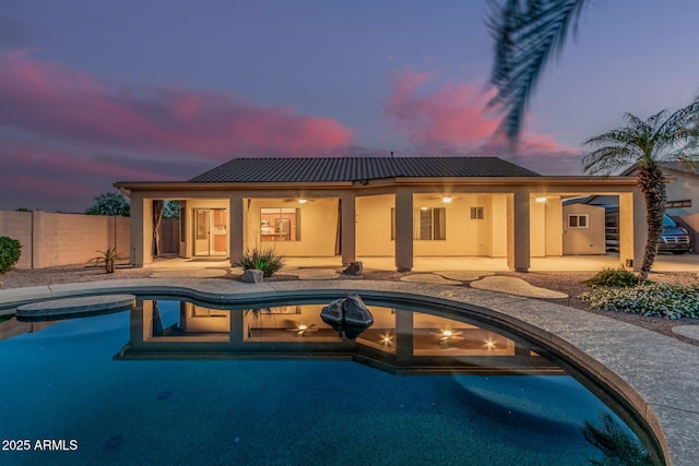 pool at dusk with an outdoor pool, a patio, ceiling fan, and fence