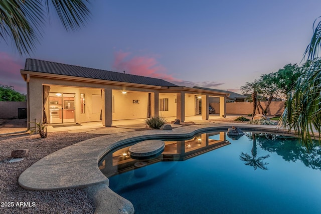 pool at dusk with a fenced in pool, a patio, central AC unit, and fence private yard