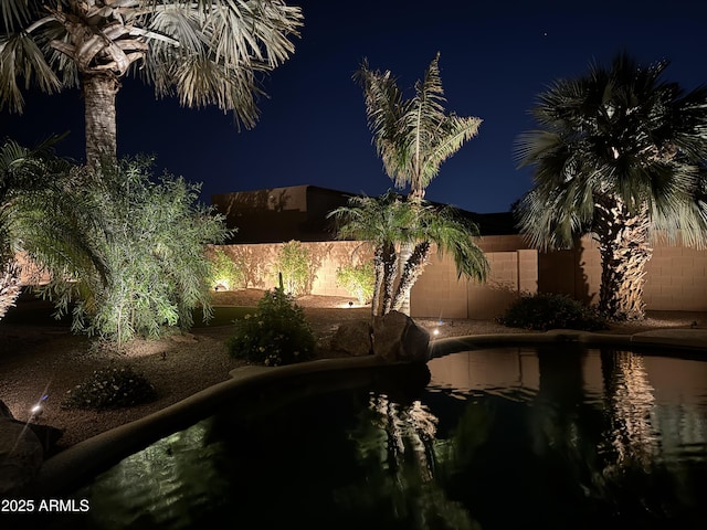 yard at night with a fenced backyard