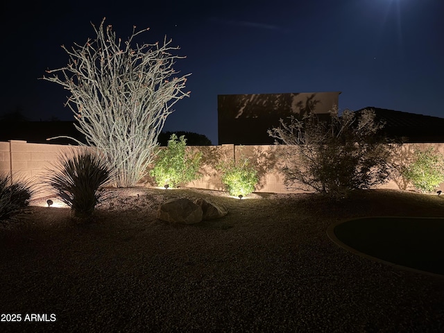 yard at twilight with a fenced backyard