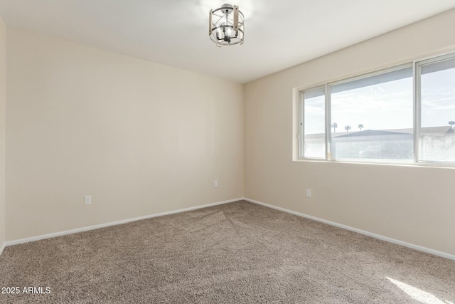 carpeted empty room with baseboards