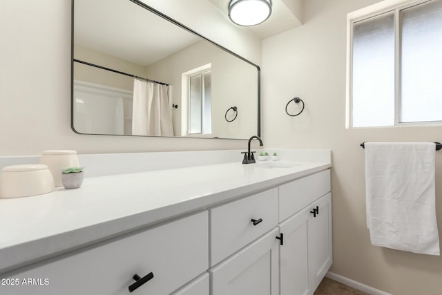 full bath with vanity and baseboards