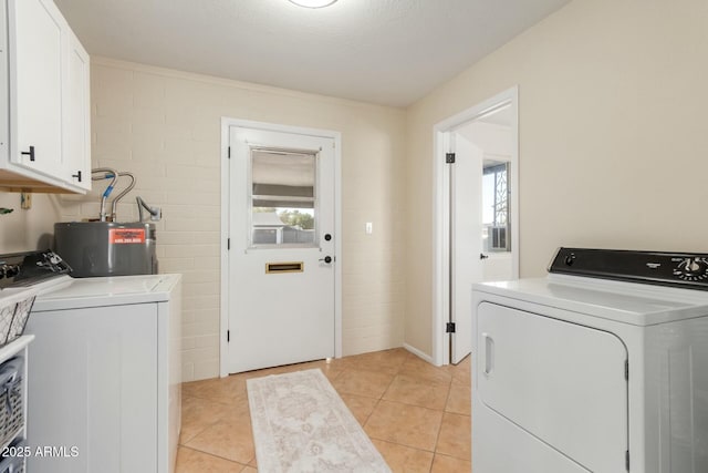 laundry area featuring cabinet space, water heater, light tile patterned flooring, and washing machine and clothes dryer