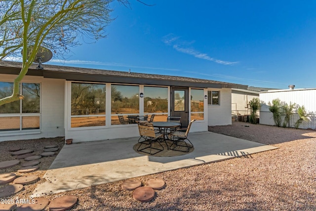 back of property featuring a patio and fence